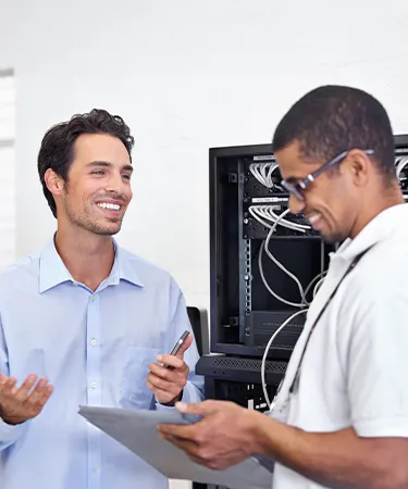 Technicians discussing IT network hardware setup.