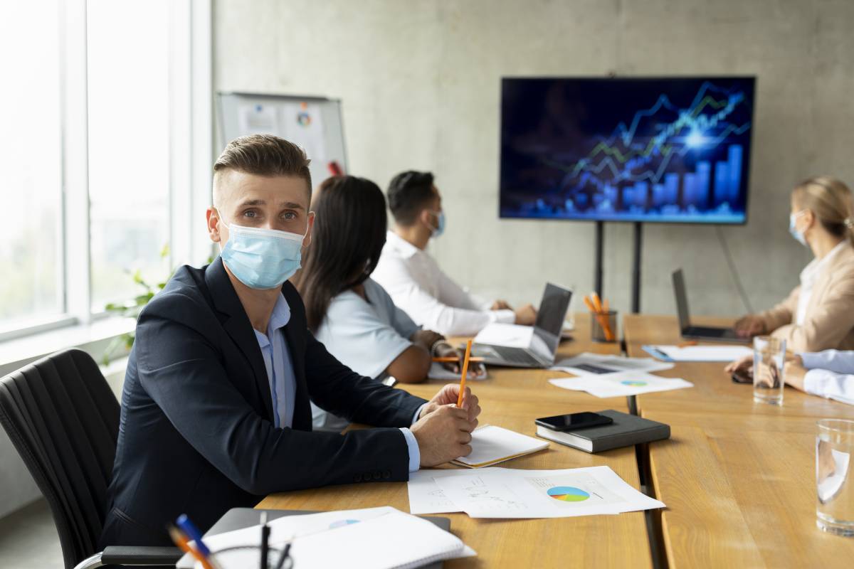 Workplace Healthcare. Multiethnic Business Team Wearing Medical Masks Having Meeting In Office