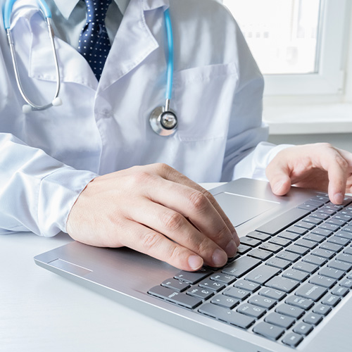 Doctor types, speaks, talks to patient by laptop. Telehealth,telemedicine,online consultation,video